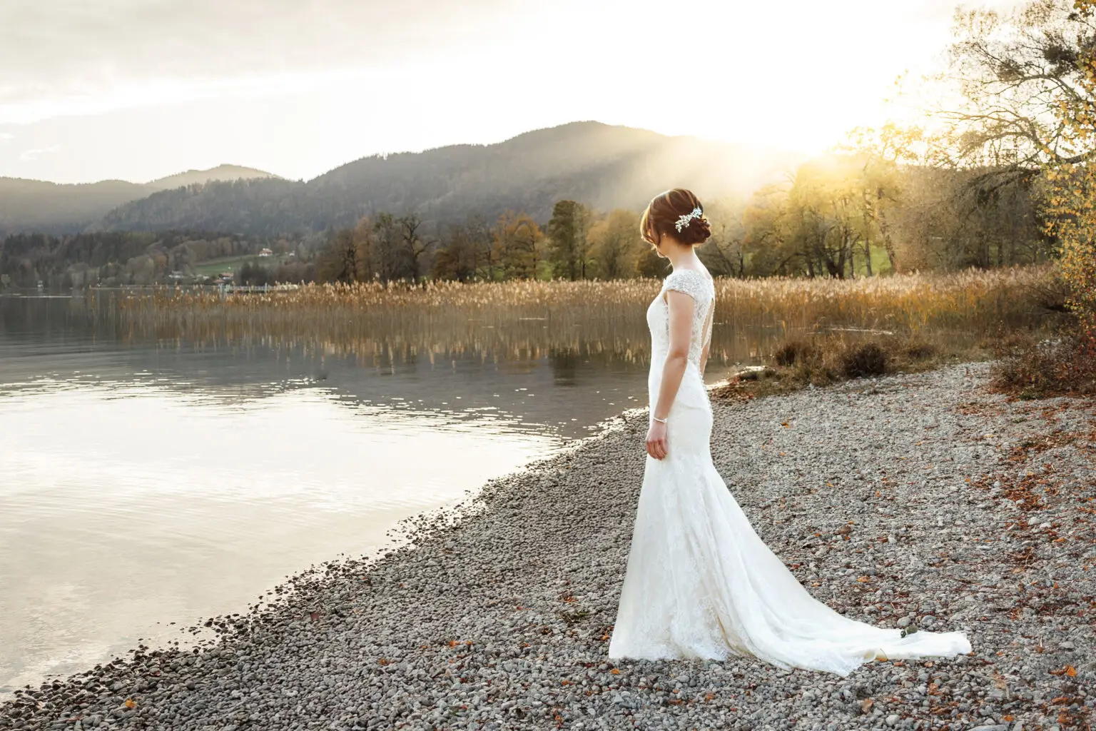 Heiraten am Tegernsee Braut mit edlem Brautkleid steht bei Gut Kaltenbrunn am See. Fotografin Stefanie Fleischmann